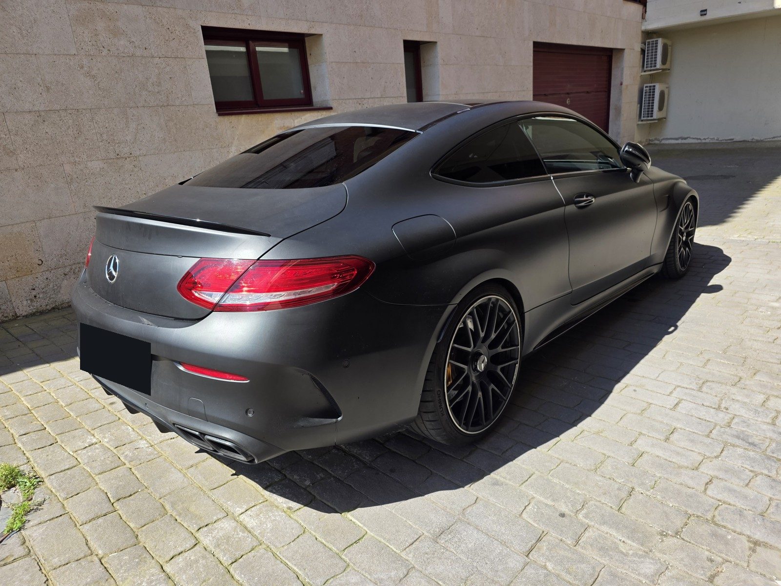 Mercedes-AMG C 63 S Coupé en vinilo negro mate, trasera tres cuartos derecha