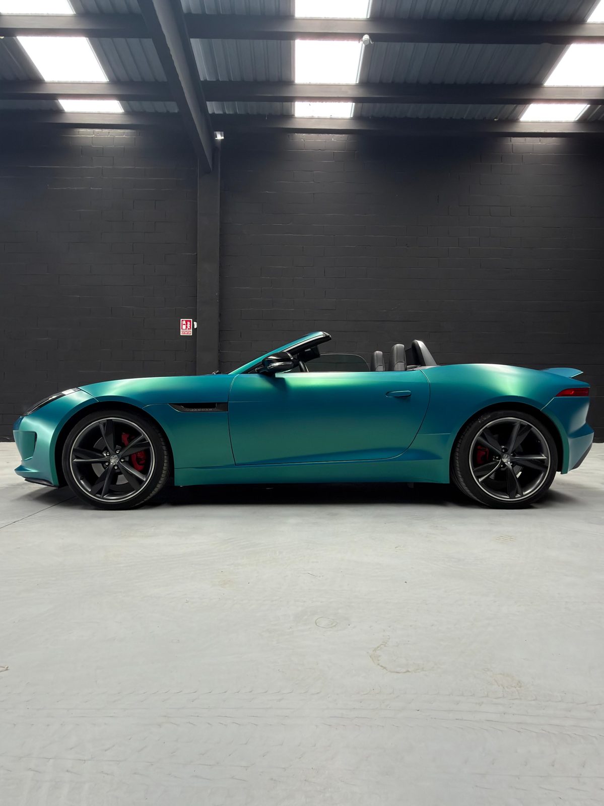 Jaguar F-Type Convertible en vinilo turquesa, descapotado, perfil lateral