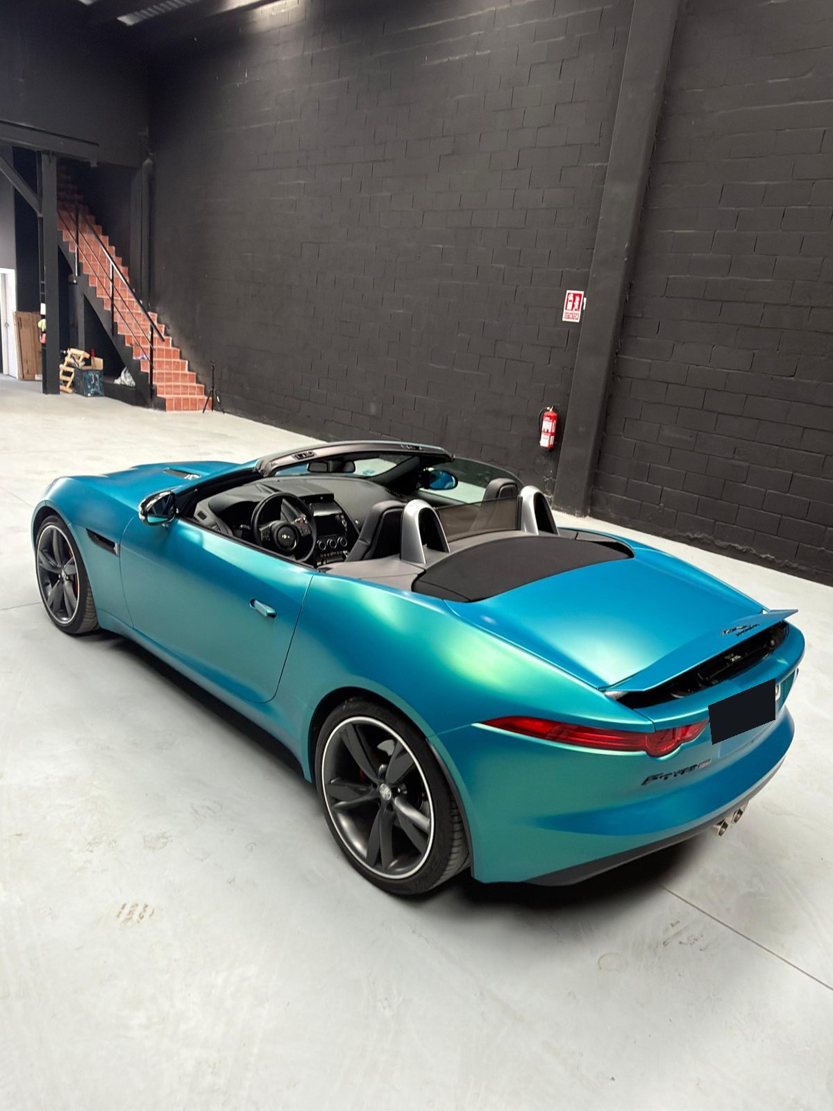 Jaguar F-Type Convertible en vinilo turquesa, descapotado, trasera con alerón