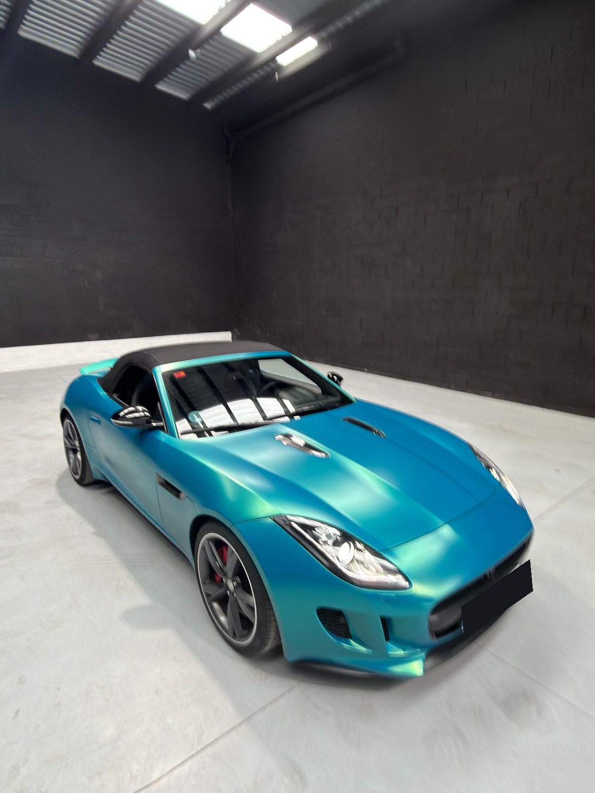 Jaguar F-Type Convertible en vinilo turquesa, capota negra, vista elevada
