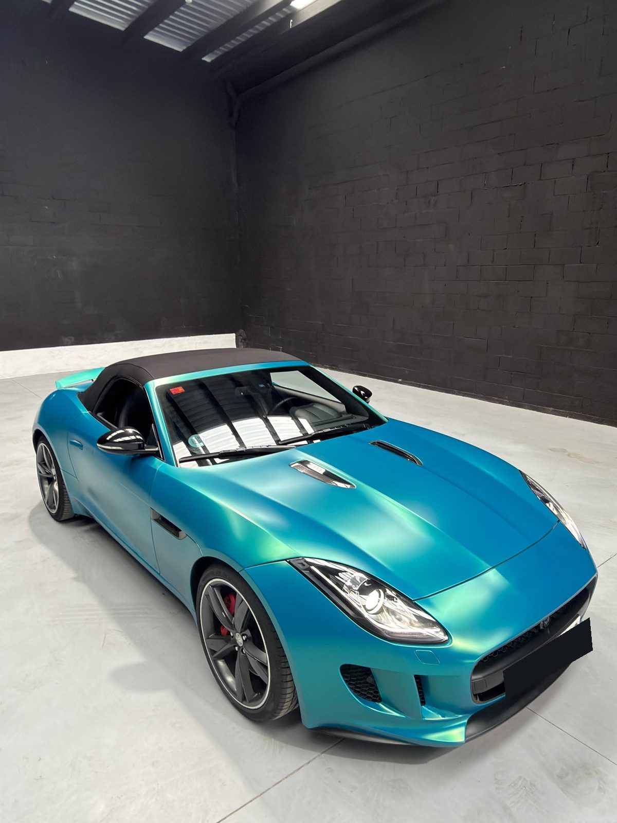 Jaguar F-Type Convertible en vinilo turquesa, capota negra, frontal tres cuartos