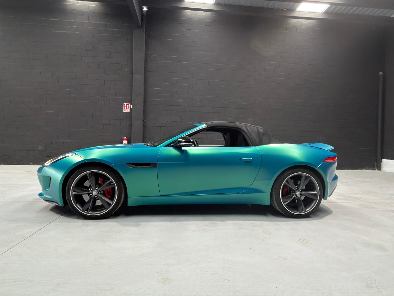 Jaguar F-Type Convertible en vinilo turquesa, perfil con capota cerrada