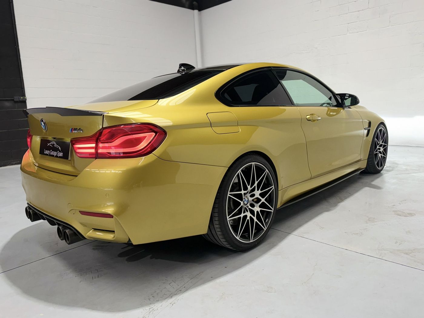BMW M4 amarillo, tres cuartos trasero derecho con llantas de radios en Y